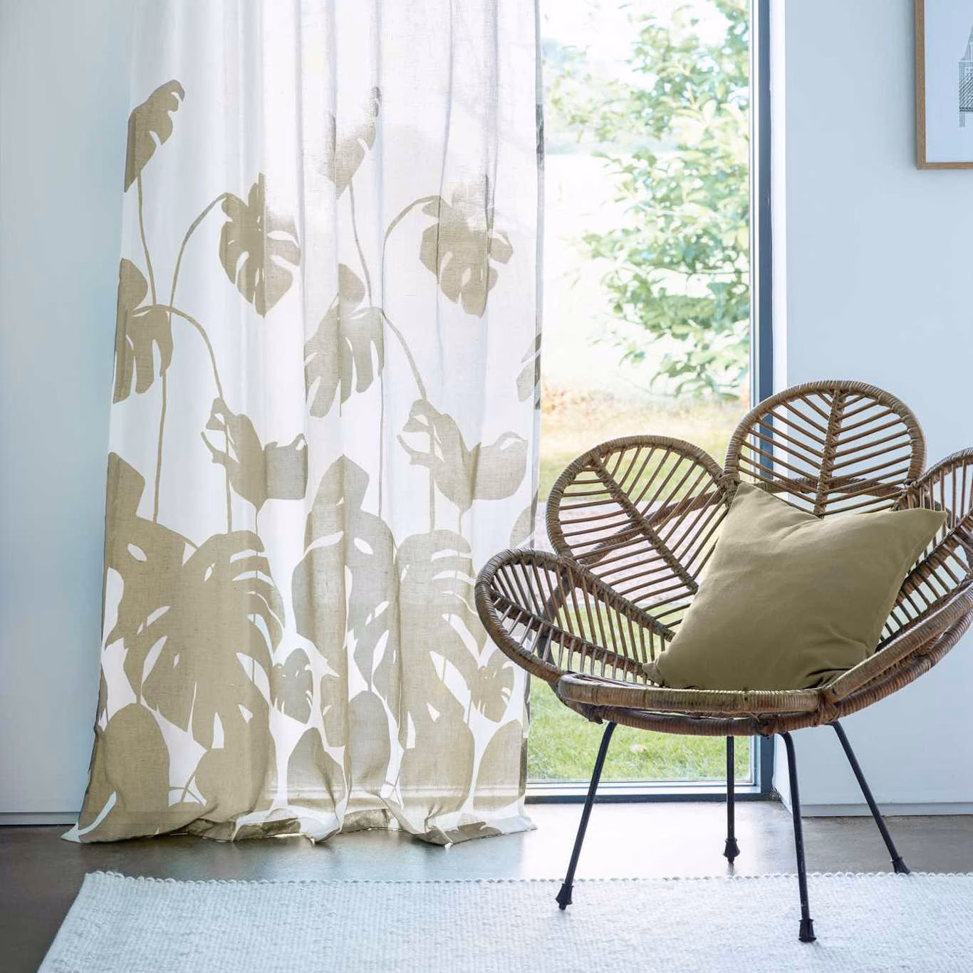Ivory sheer curtain with taupe-olive split-leaf botanical silhouettes in sunlight