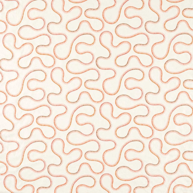 Cream embroidered fabric with warm coral looping trails in a dense repeating pattern