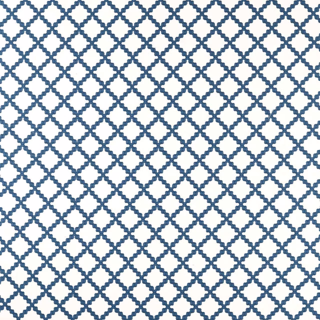 Midnight-blue geometric lattice embroidery on a crisp white fabric ground