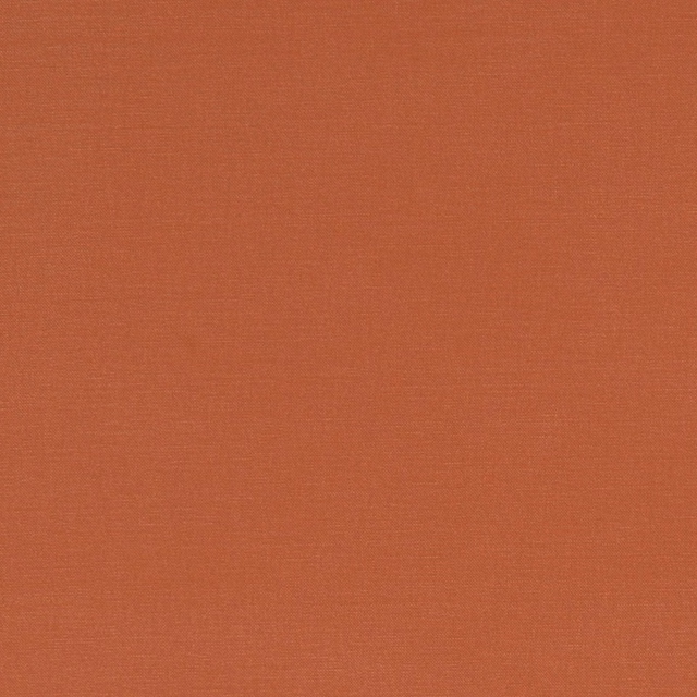 Close-up of muted paprika terracotta fabric with a fine, even woven texture