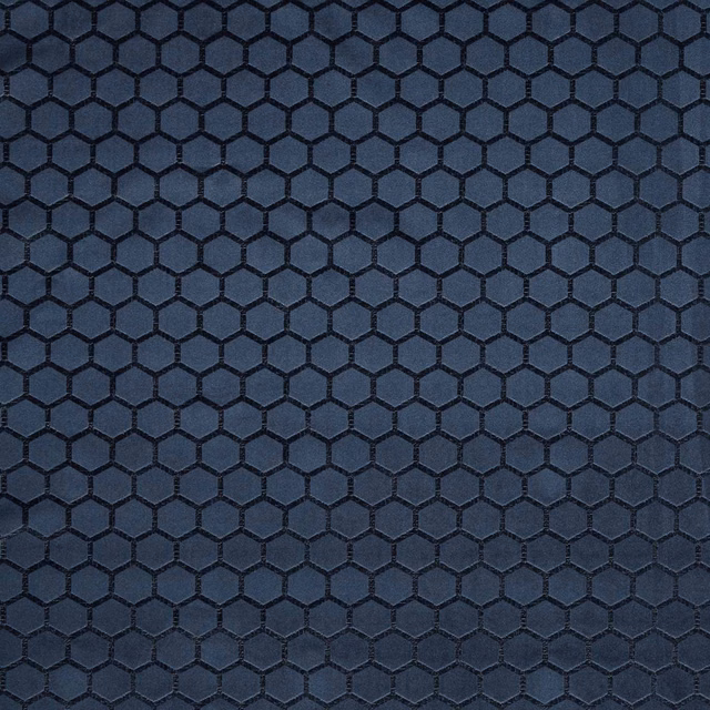 Deep midnight-blue textile with raised black hexagonal lattice and subtle woven sheen