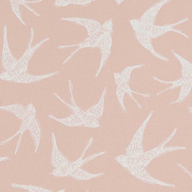 Ivory flying birds scattered across a softly textured dusty blush-pink fabric