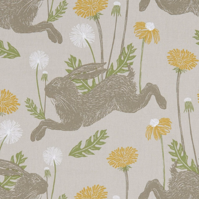 Taupe running hares, mustard dandelions and green leaves on pale woven linen fabric