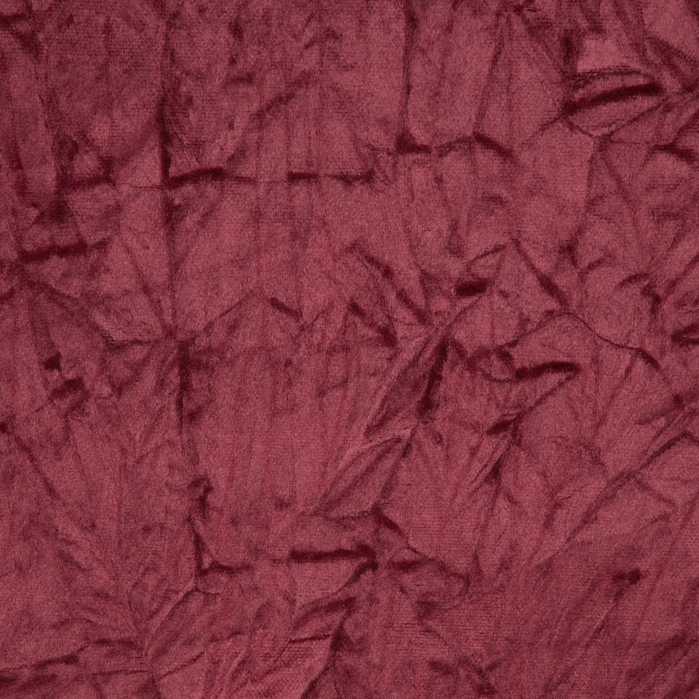 Deep mulberry-red fabric with dark crumpled abstract markings and tactile woven texture