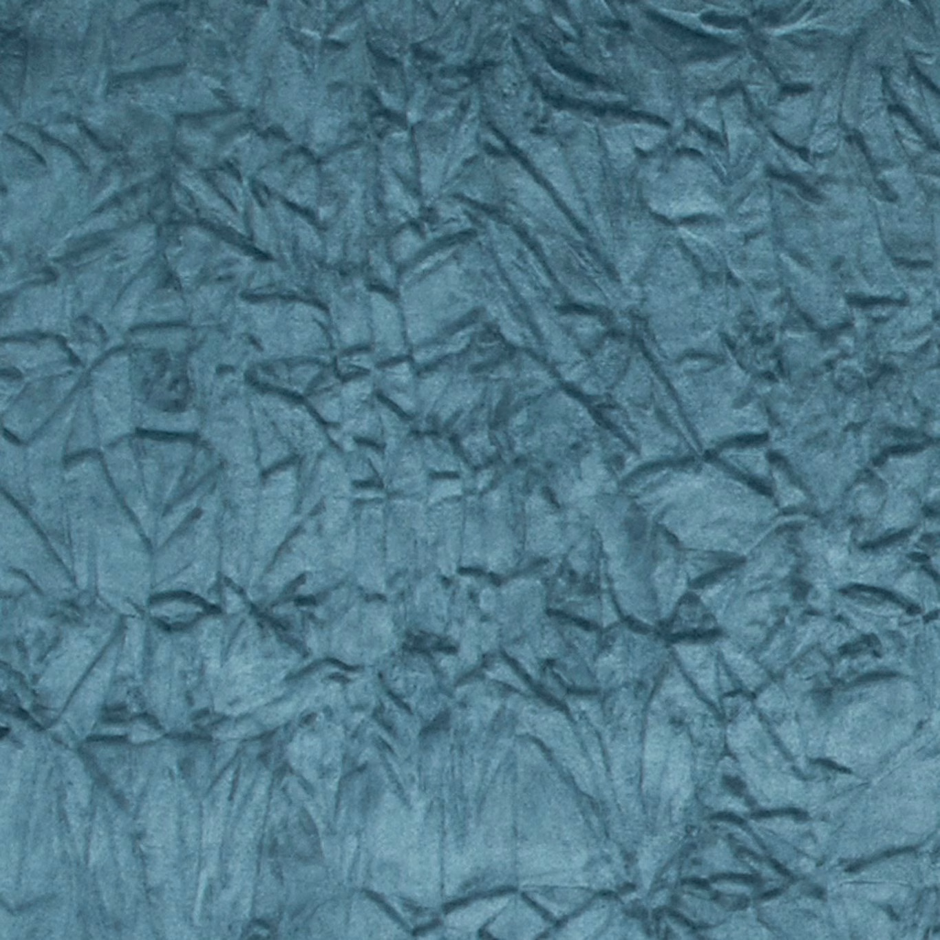 Close-up of cool teal crushed textile with dark folded, leaf-like surface markings