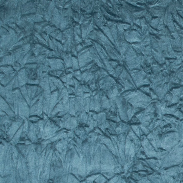 Close-up of cool teal crushed textile with dark folded, leaf-like surface markings