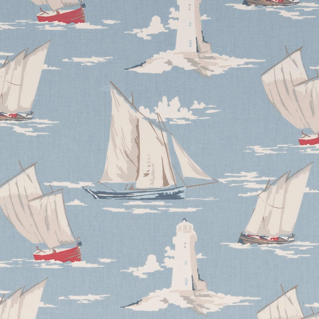 Muted blue fabric with cream sailboats, red hulls and white lighthouse motifs