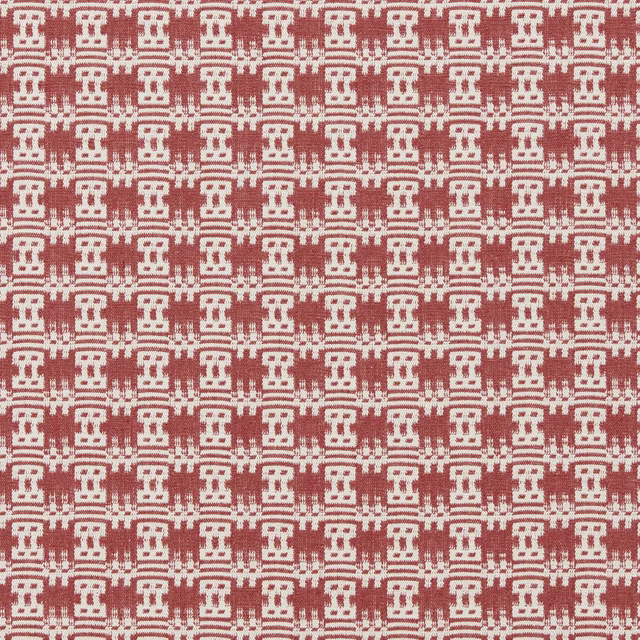 Close-up of a woven pink-red geometric fabric with cream repeated motifs