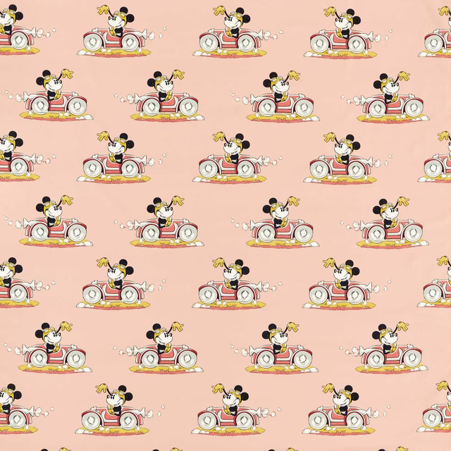 Minnie Mouse driving a red car on soft pink printed fabric