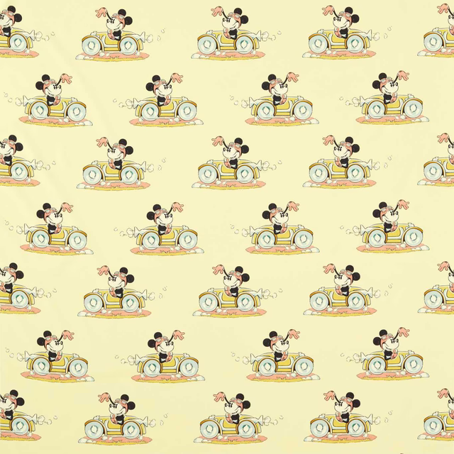 Minnie Mouse driving a small car on soft sherbet yellow fabric