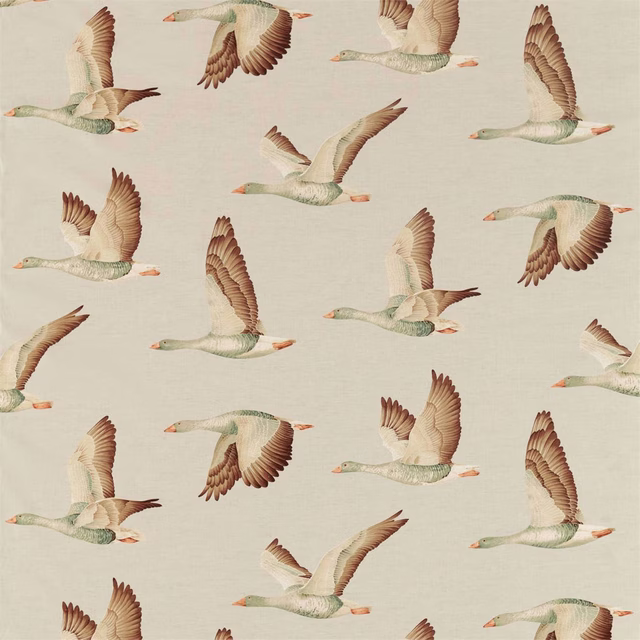 Printed geese in sage, cream and brown flying across a warm linen ground