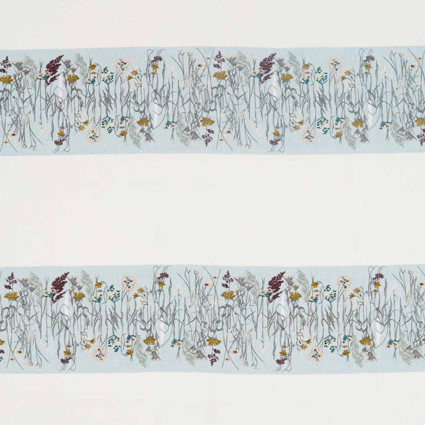 Swatch of floral fabric with pale blue ground and slender meadow stems