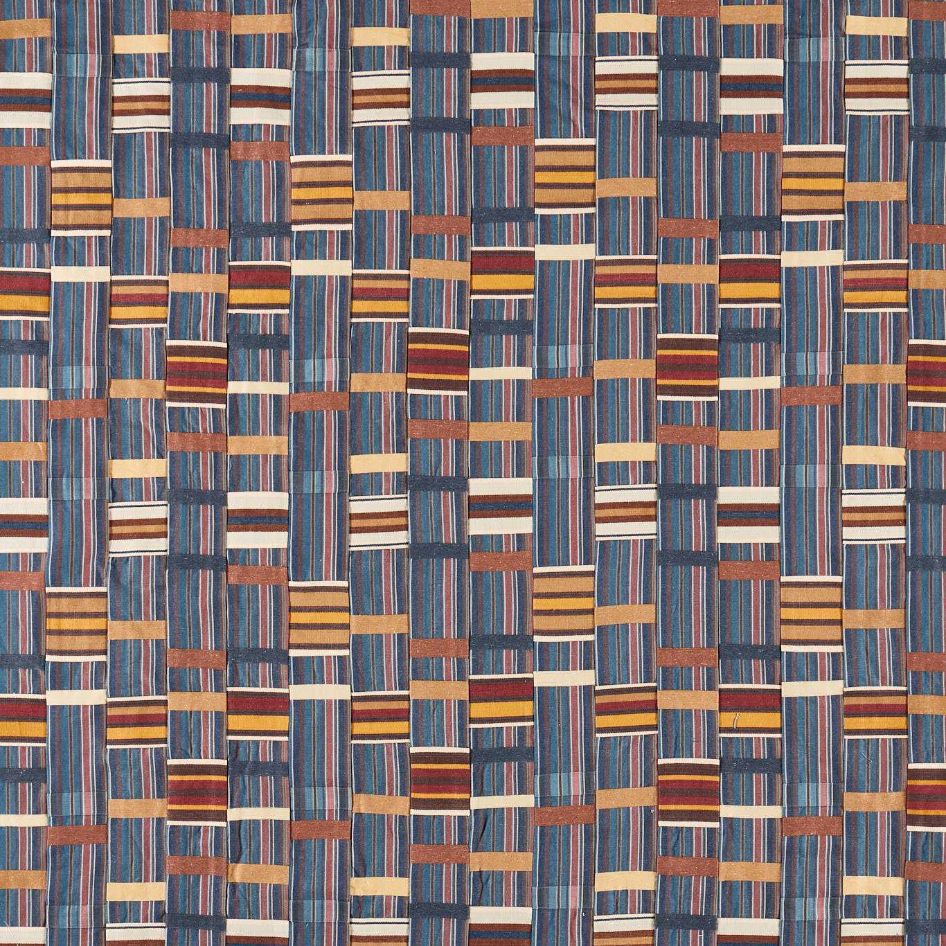 Woven geometric fabric with blue, russet, cream and gold striped blocks