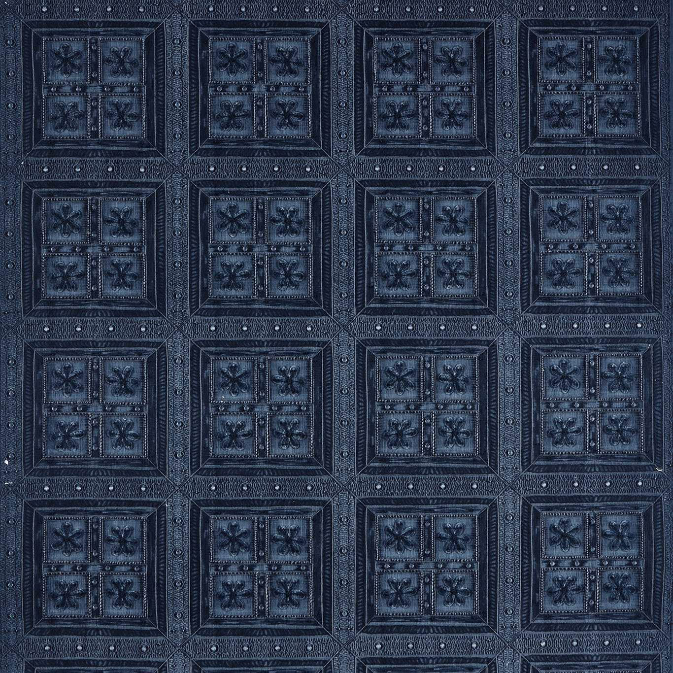 Dark denim-blue geometric fabric with raised square motifs and floral centres
