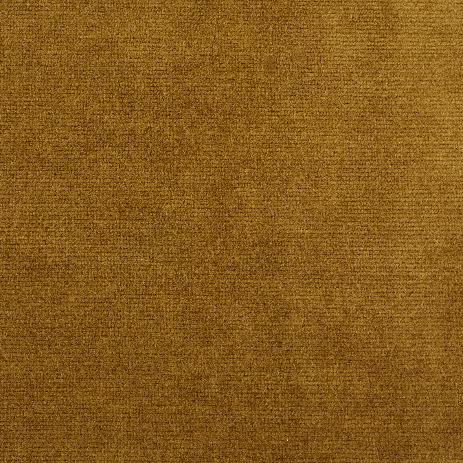 Close-up of warm old gold velvet with a subtle mottled pile texture