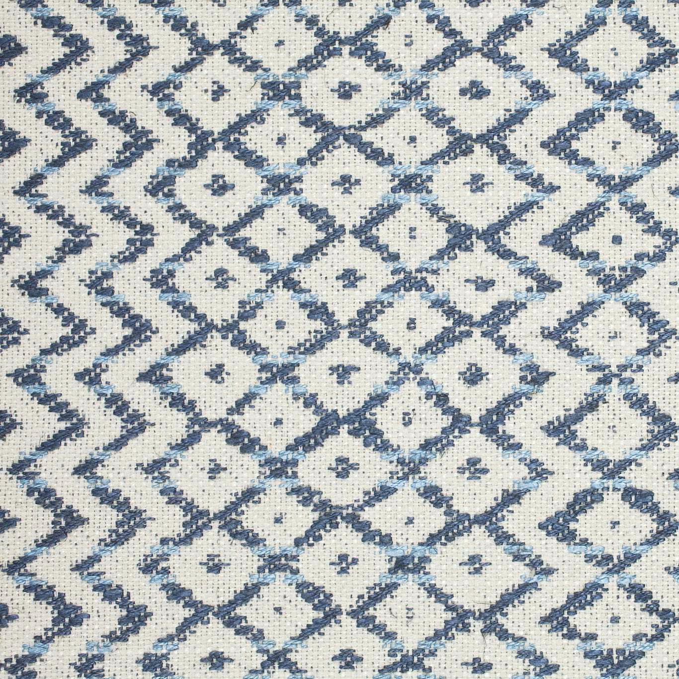 Close-up of indigo and ivory woven diamond lattice fabric with textured surface