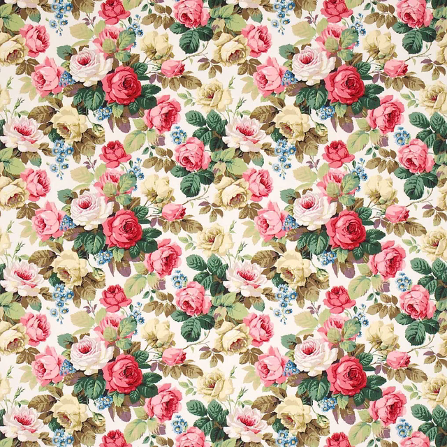 Large-scale rose floral fabric on a soft cream ground with pink, green and blue accents