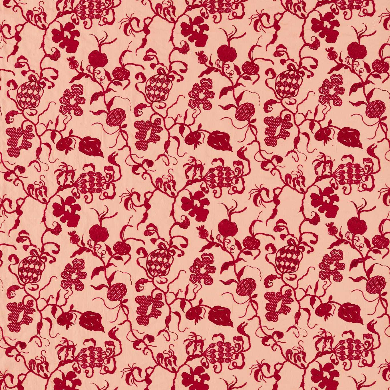 Close-up of red botanical print on a soft conch-pink fabric ground