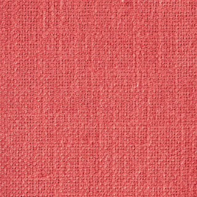 Close-up of warm coral-pink woven fabric with a textured basket weave