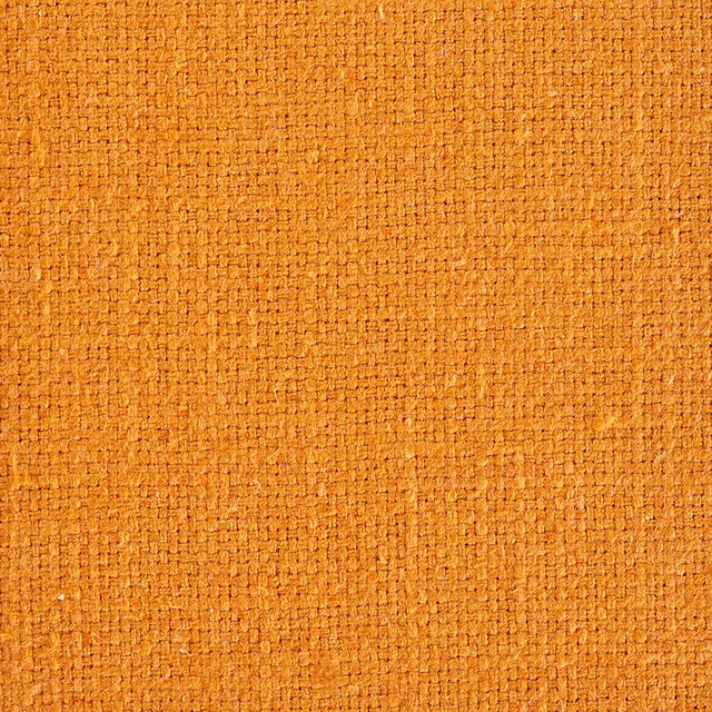 Close-up of warm saffron-gold woven fabric with a tight textured plain weave