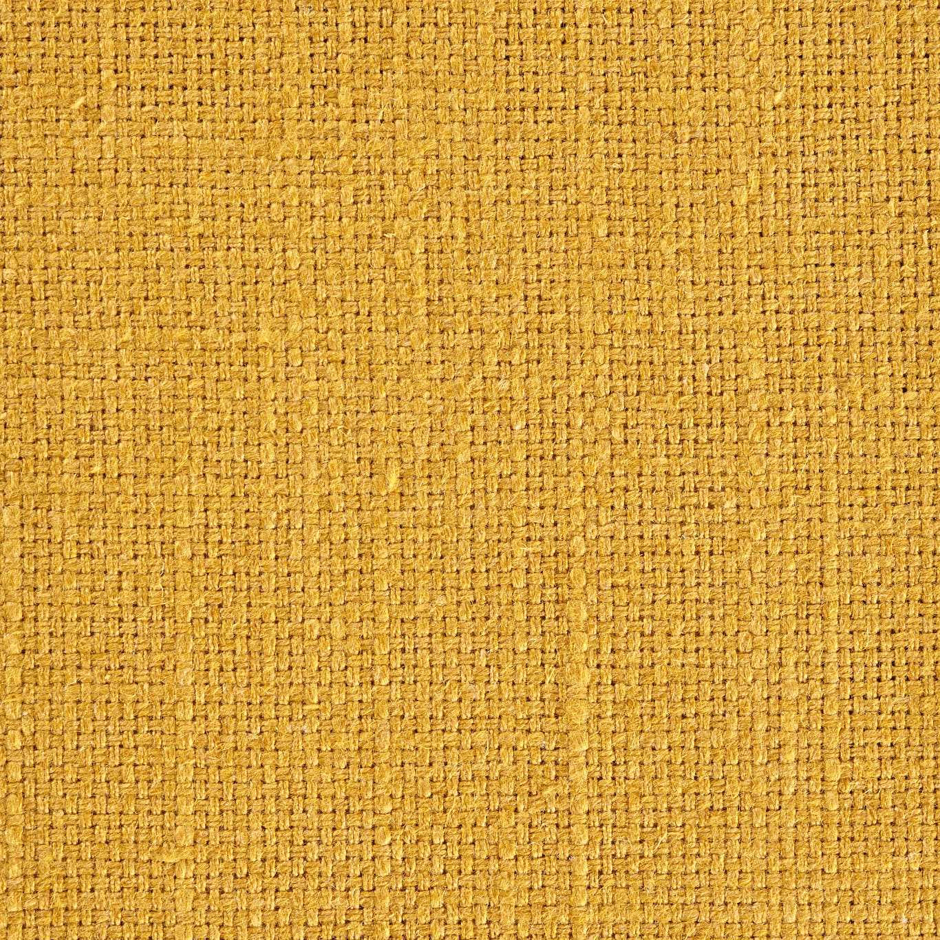 Close-up of turmeric-gold woven fabric with a tight textured basket weave