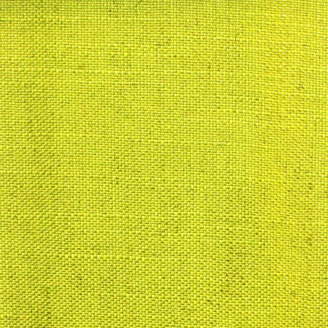 Close view of vivid citron yellow fabric with a fine, textured plain weave