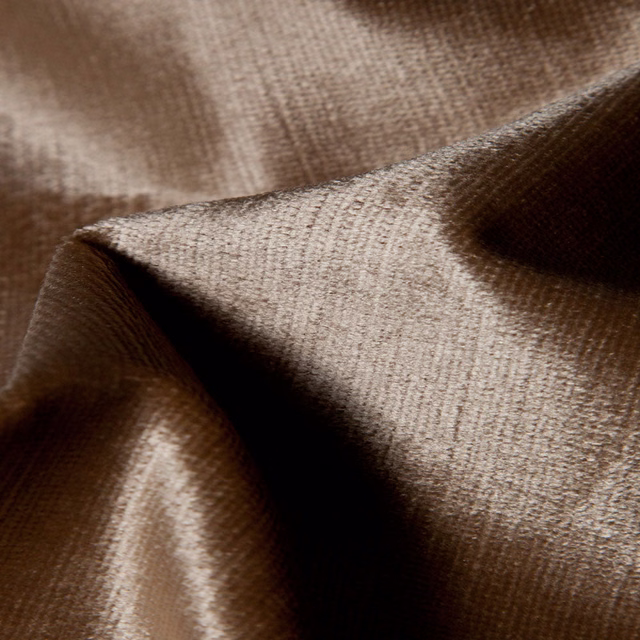 Warm taupe-brown fabric with fine crosshatched weave folded into soft curves