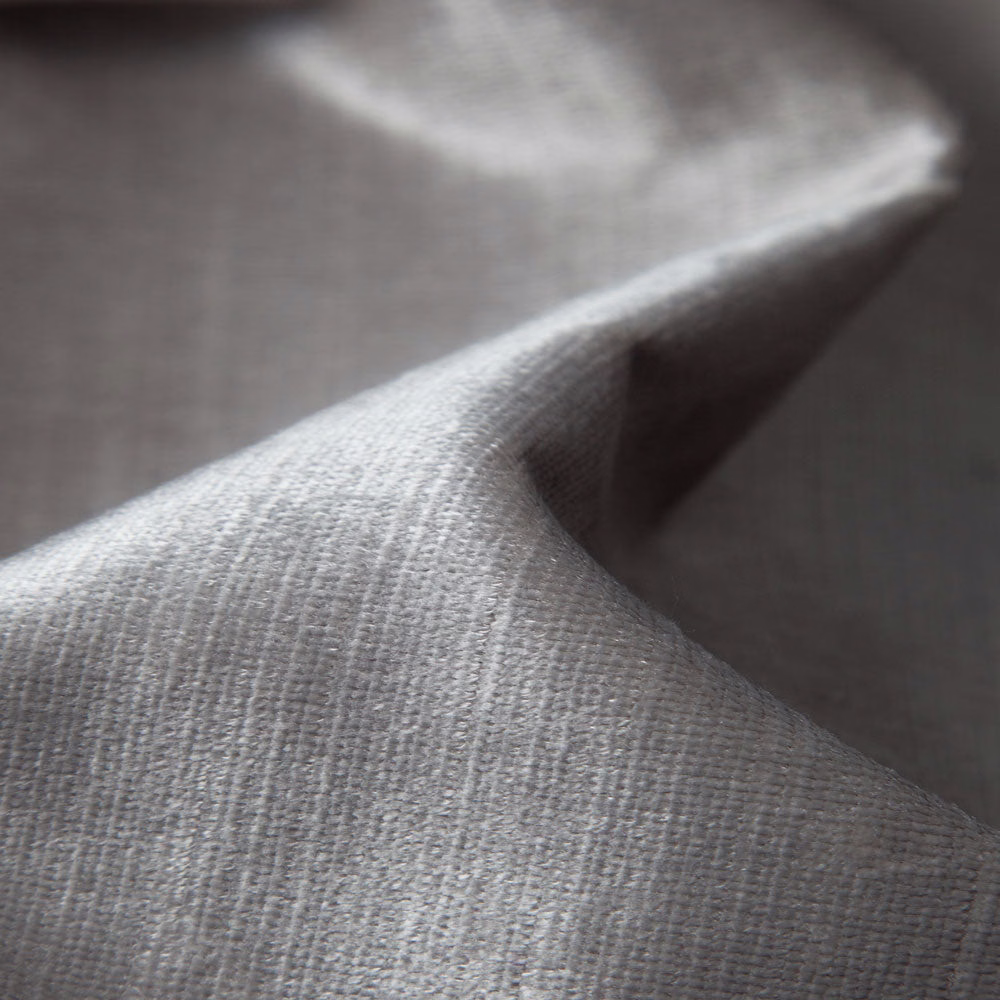 Soft warm-grey plain weave with fine vertical texture, folded in close-up light