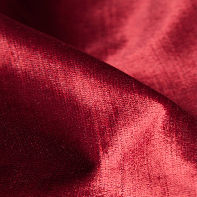 Deep crimson-red woven textile with bright fold highlights and darker burgundy shading