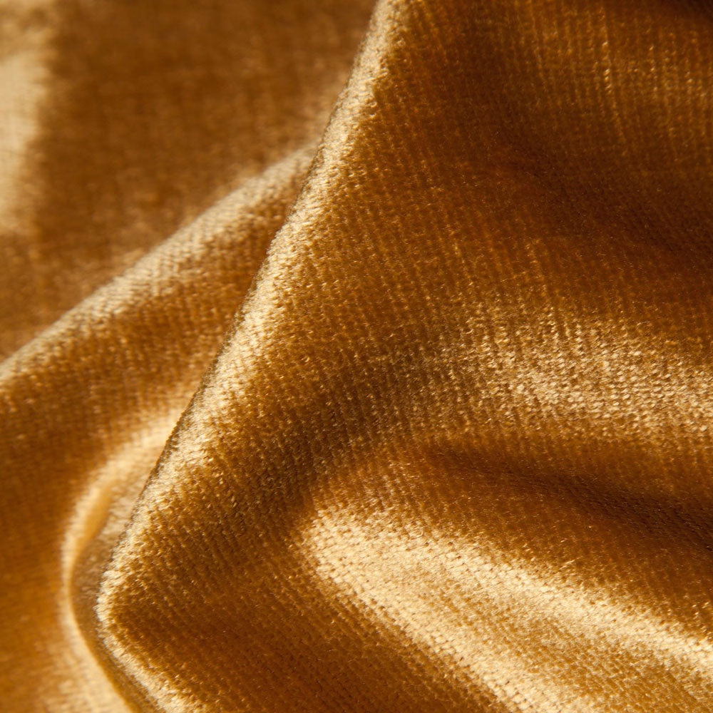 Golden ochre plain fabric with a directional velvety nap catching warm light
