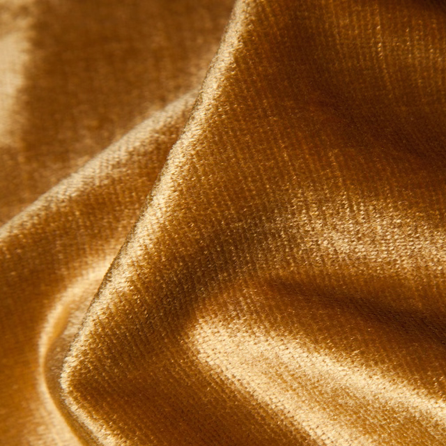 Golden ochre plain fabric with a directional velvety nap catching warm light
