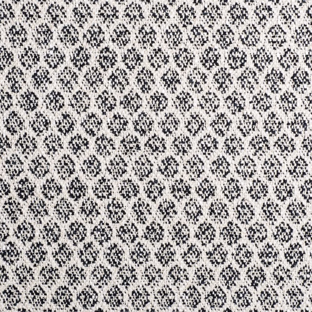Charcoal geometric flecks woven across an ivory textured fabric ground