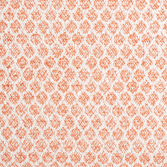 Warm coral-orange and white woven fabric with small broken geometric motifs