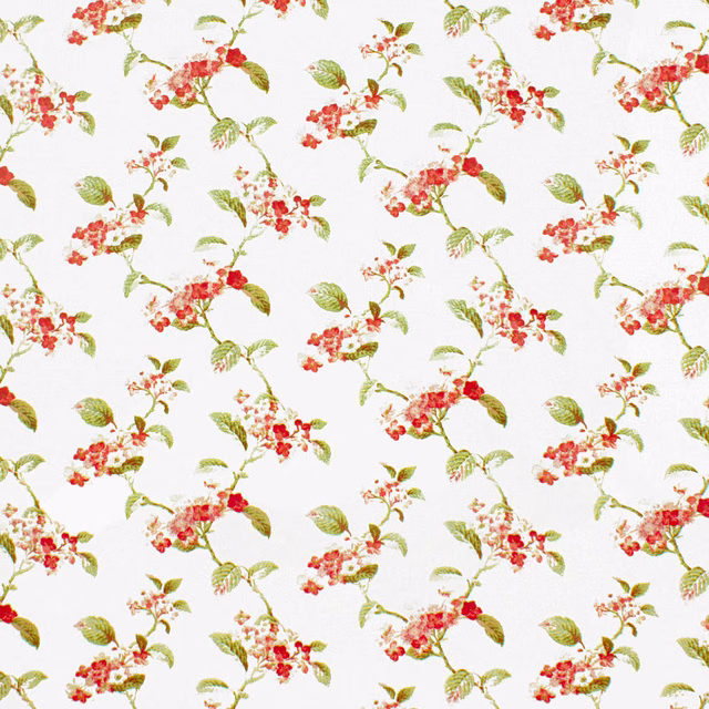 White fabric with scattered coral blossoms and green leafy floral branches