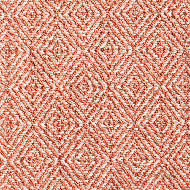 Pumpkin orange and cream woven fabric with raised repeating diamond motifs