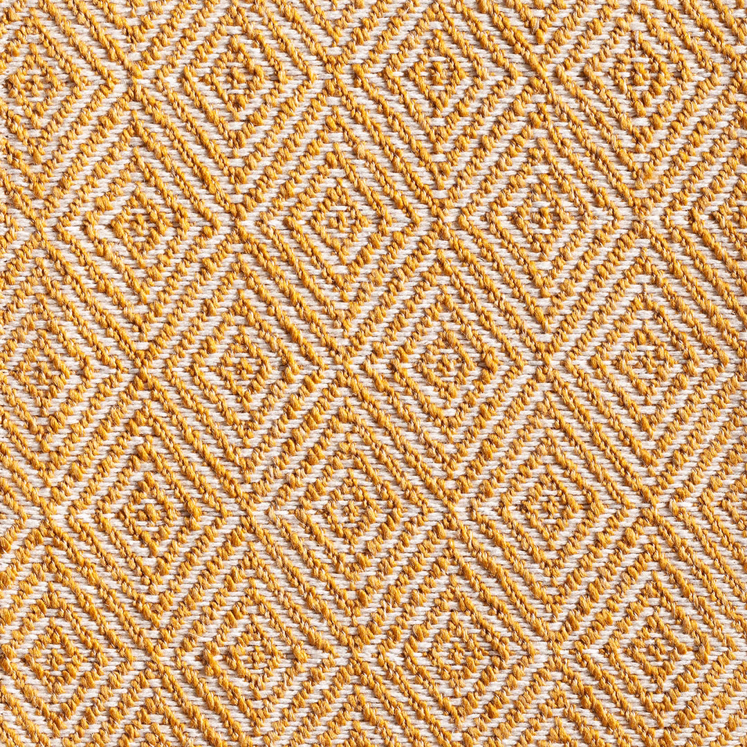 Turmeric and cream woven fabric with raised repeating diamond motifs and tactile diagonal yarns