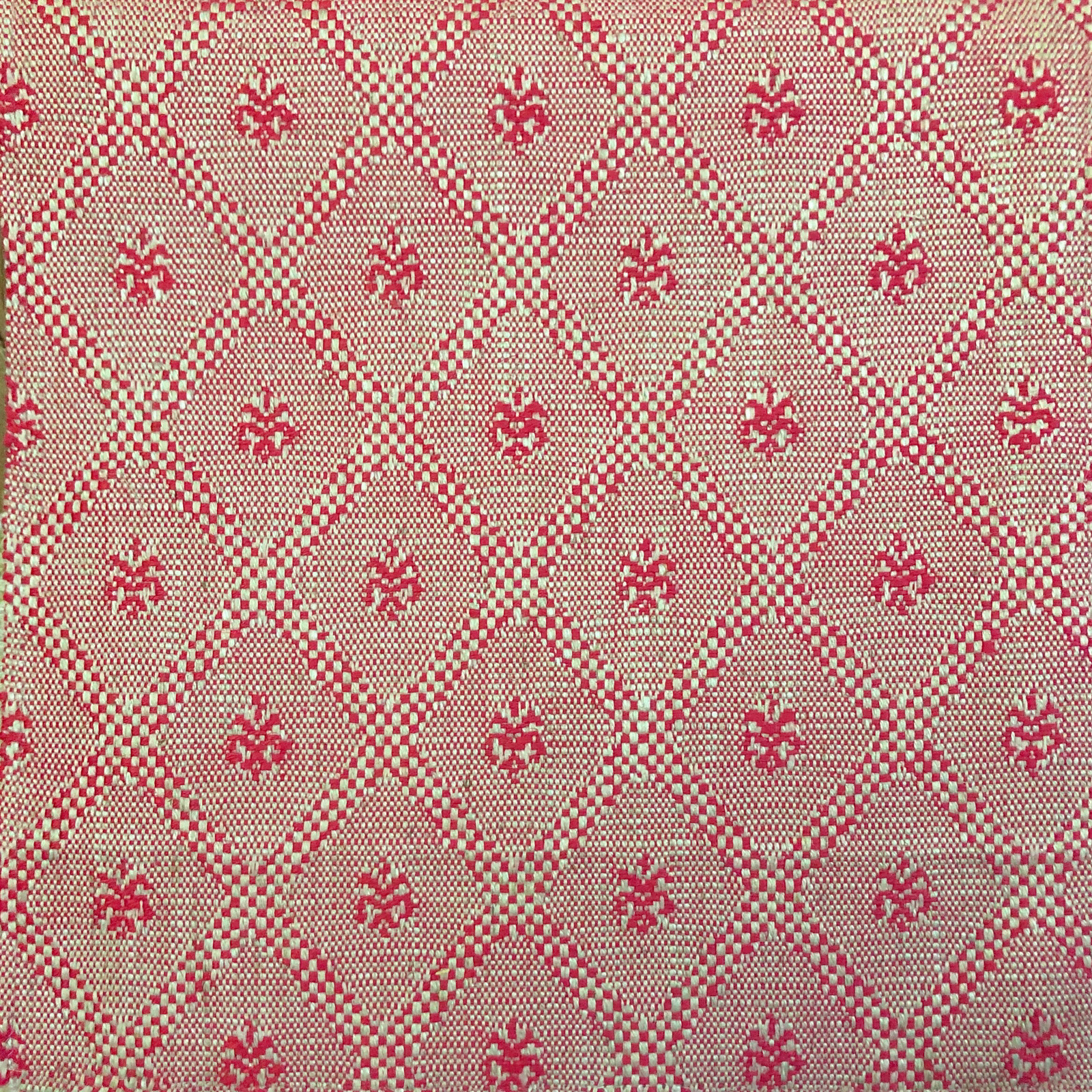 Warm beige woven fabric with red diamond lattice and floral motifs