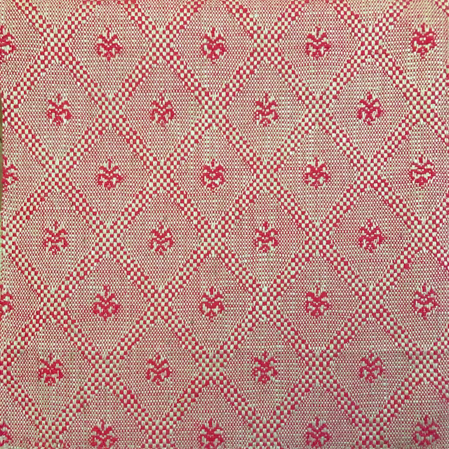 Warm beige woven fabric with red diamond lattice and floral motifs