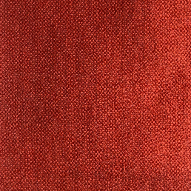 Close-up of dense terracotta-red woven fabric with fine tonal texture
