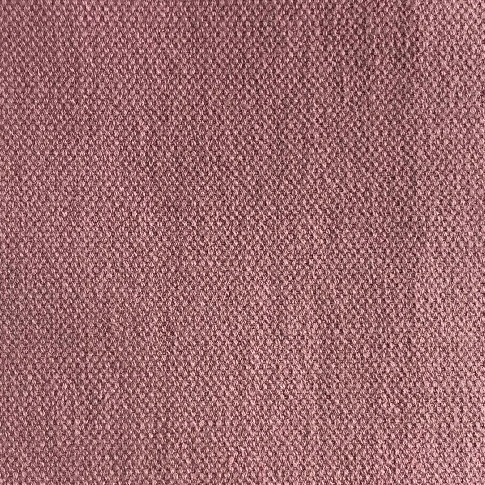 Close-up of muted dusty rose fabric with a fine, tightly interlaced woven texture