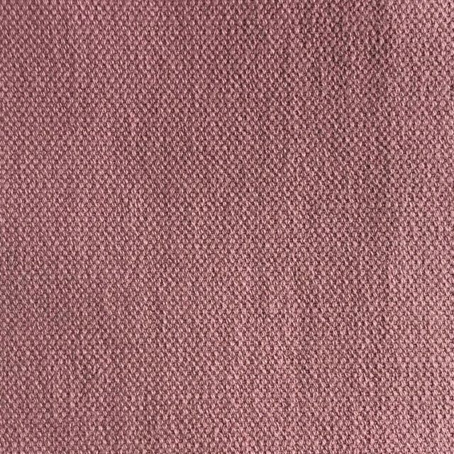 Close-up of muted dusty rose fabric with a fine, tightly interlaced woven texture