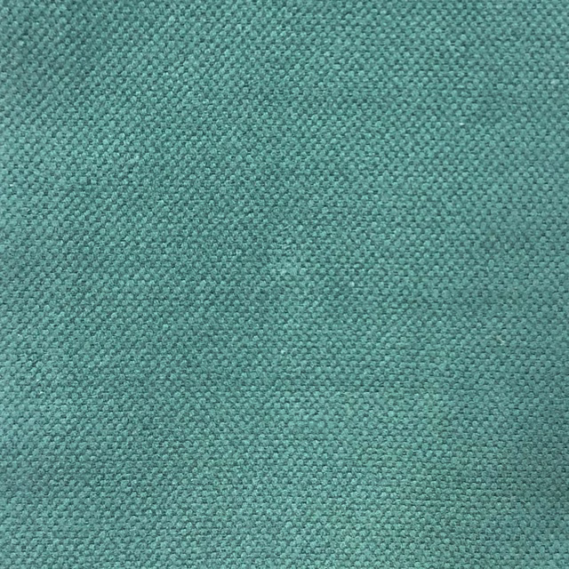 Close-up of muted teal woven fabric with a fine, softly mottled texture