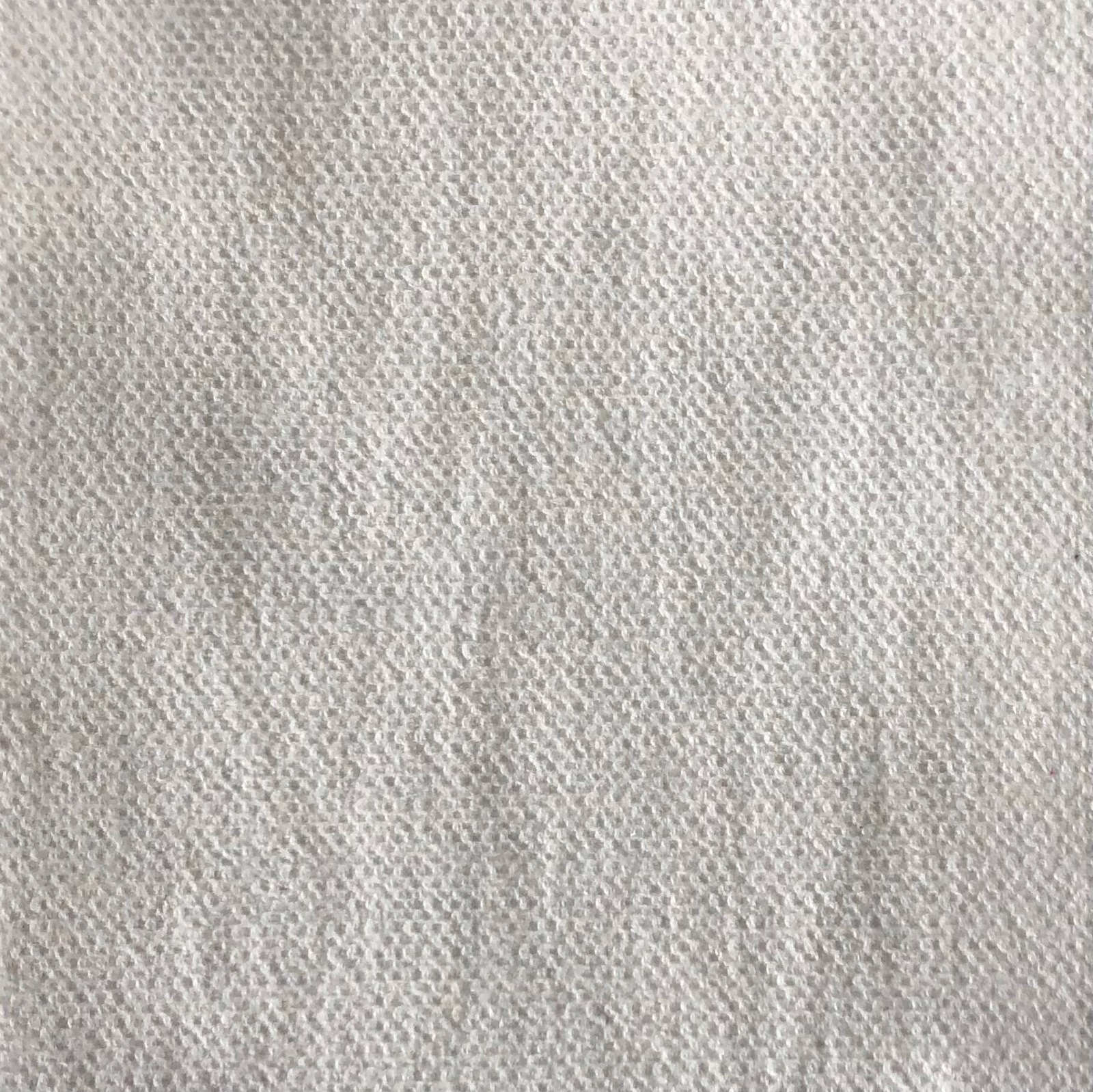 Close-up of pale ivory-grey fabric with a softly irregular nubby woven texture