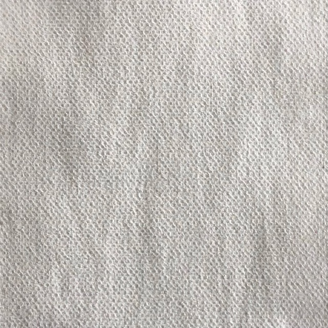 Close-up of pale ivory-grey fabric with a softly irregular nubby woven texture