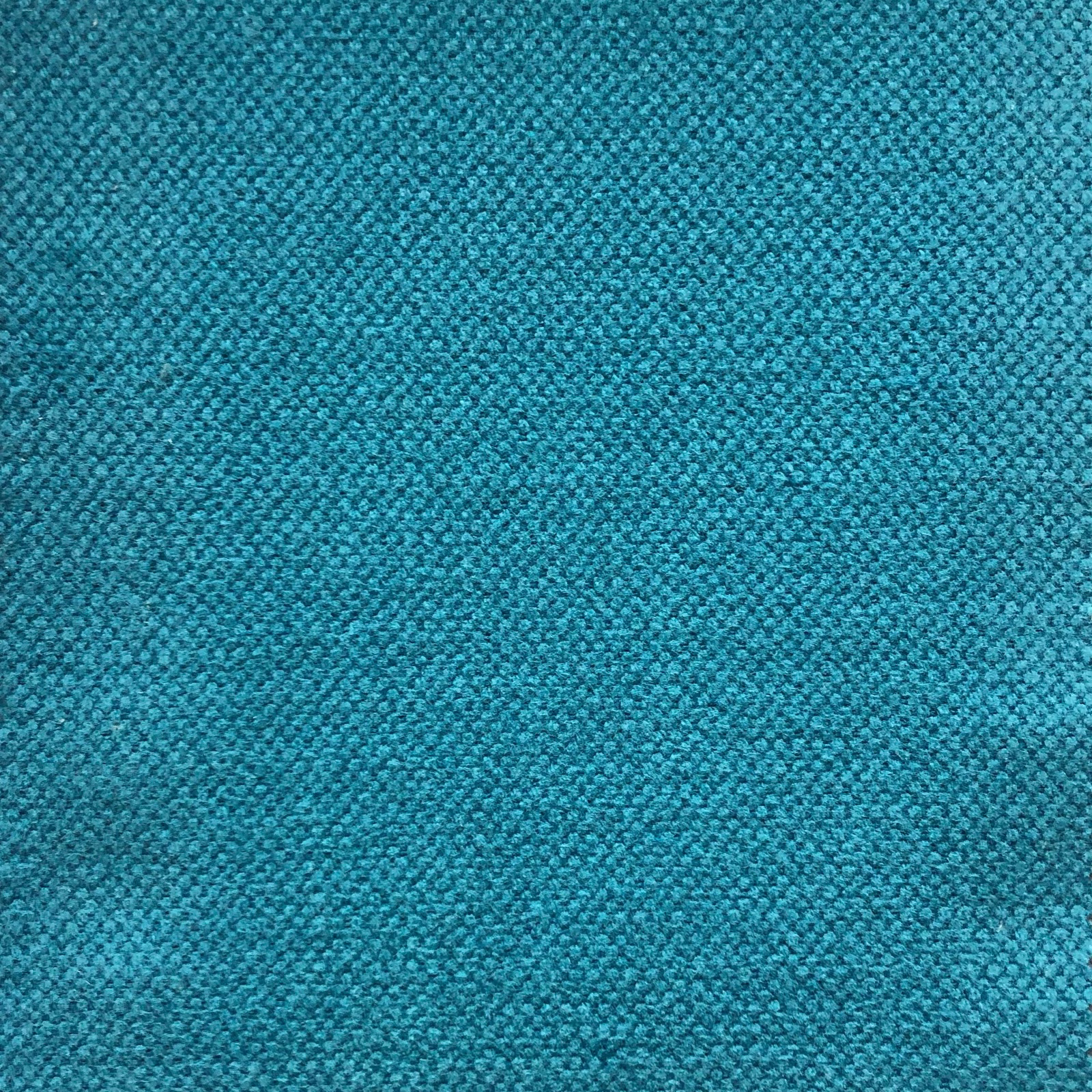 Close-up of deep blue teal fabric with a dense, pebbled woven texture