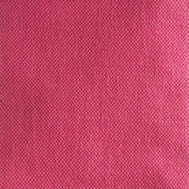 Close-up of deep raspberry pink fabric with a fine, subtly variegated woven texture