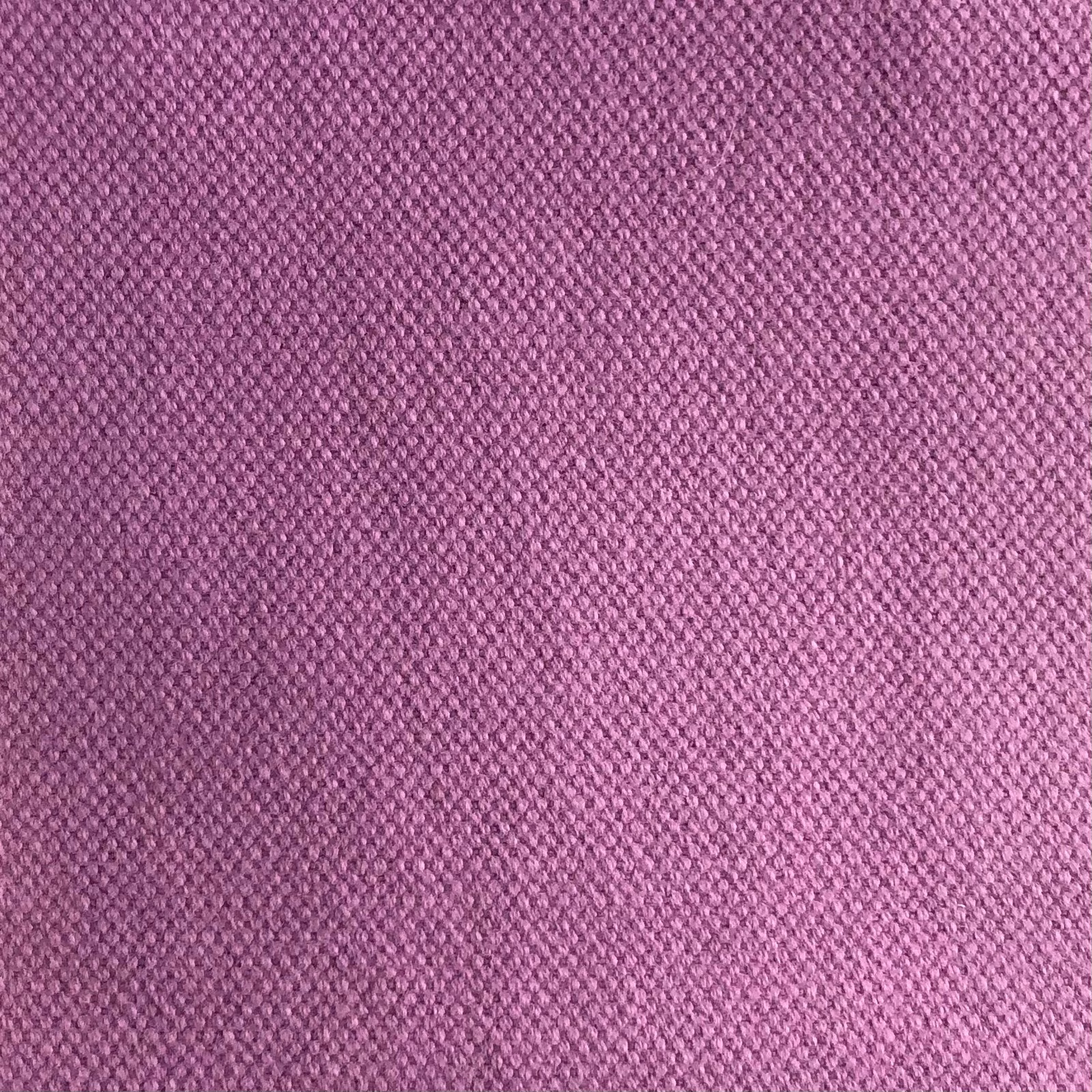 Close-up of dusty mauve-pink fabric with a compact, subtly diagonal woven texture