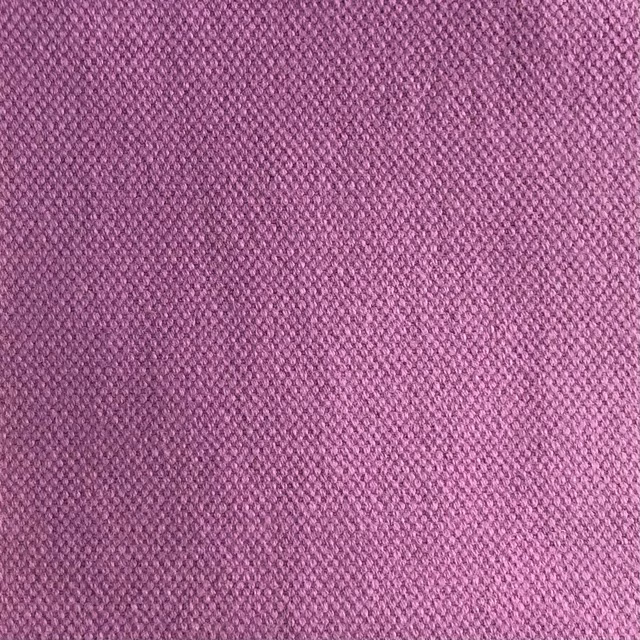 Close-up of dusty mauve-pink fabric with a compact, subtly diagonal woven texture