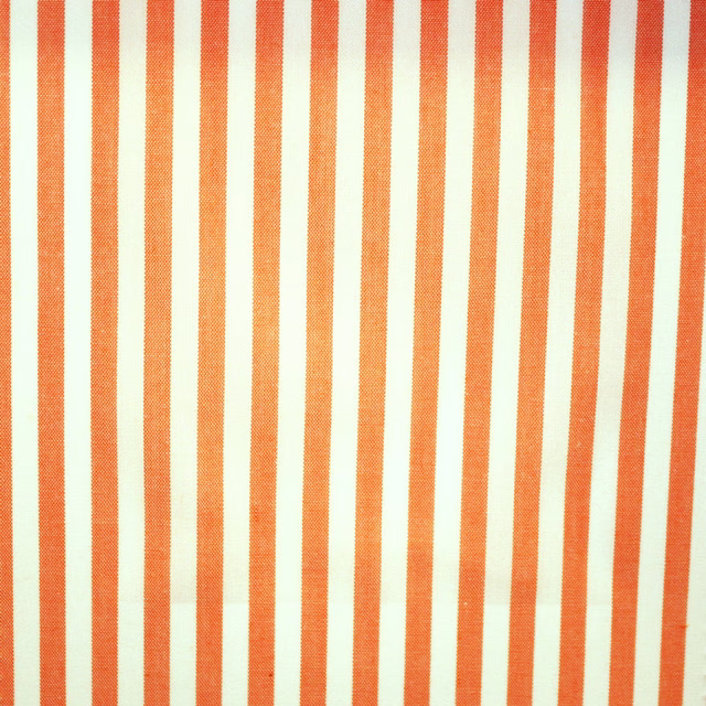 Burnt-orange and ivory vertical stripes in a fine, lightly textured weave
