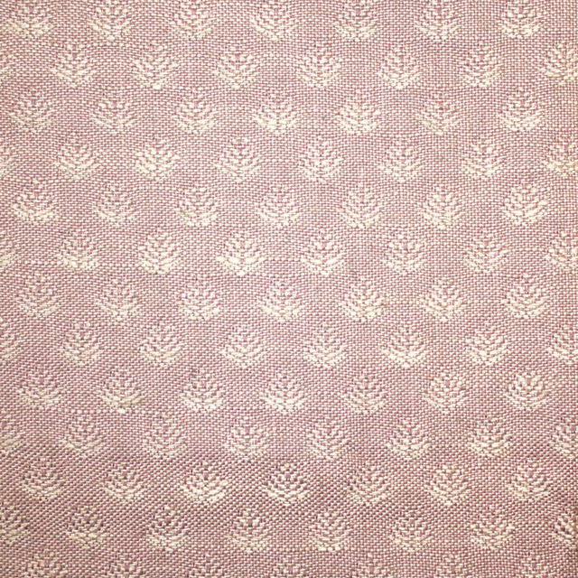 Dusty blush-pink woven fabric with repeating small ivory floral motifs